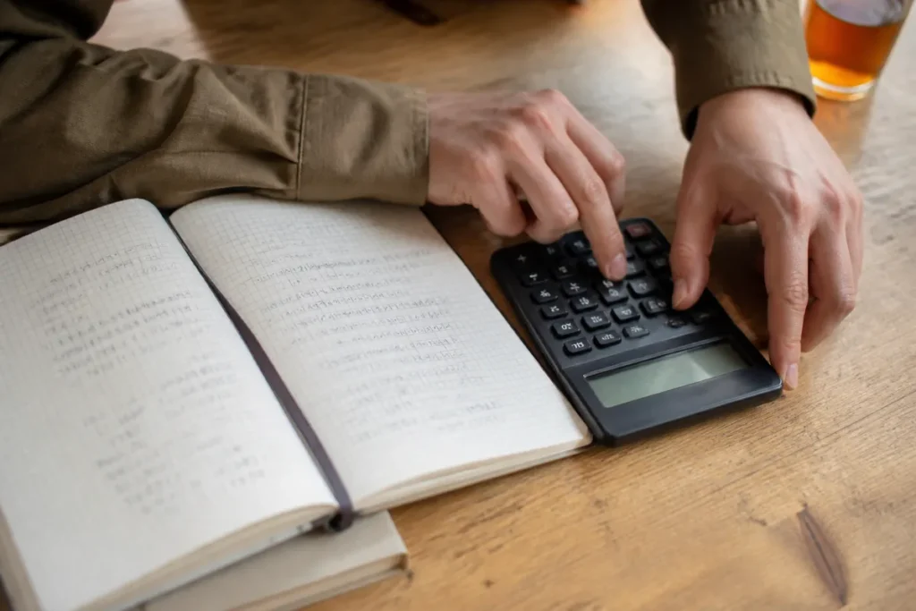 Maos calculando a media das notas do Enem para estimar a nota de corte do ProUni