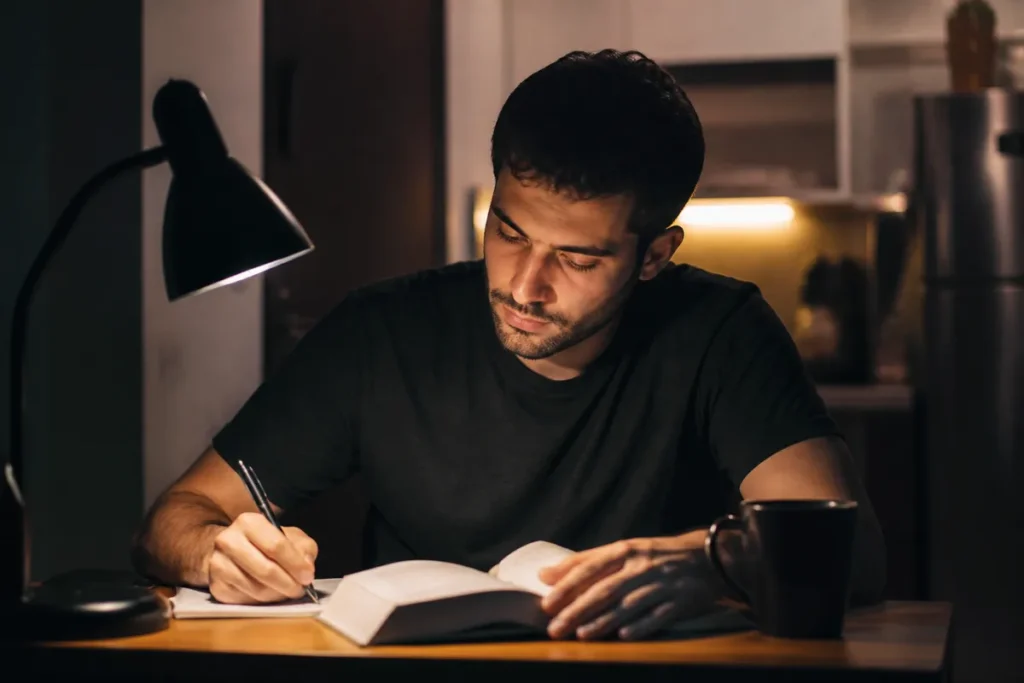 Adulto estudando à noite em casa depois do trabalho, voltando a estudar para o Enem