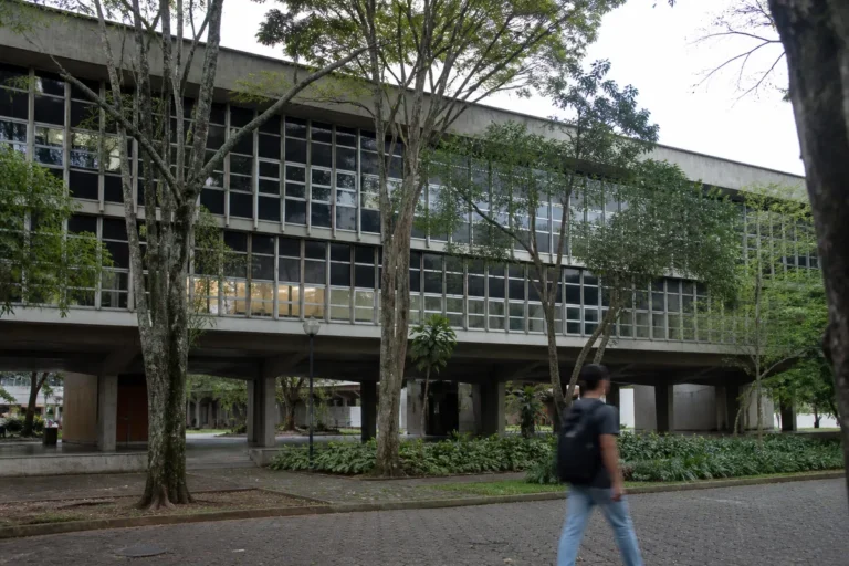 nota de corte da ufmg no Sisu: prédio acadêmico de universidade federal com estudante revisando material sobre a mesa