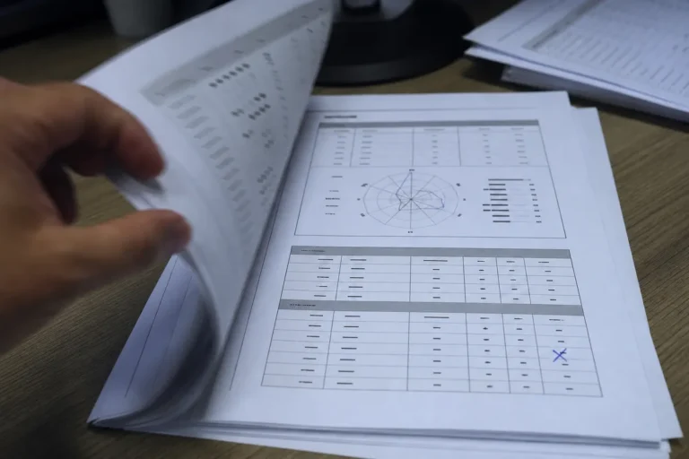 Nota do Enem para Administração: mão folheando a lista de entradas do curso por turno com o boletim do Enem parado no centro